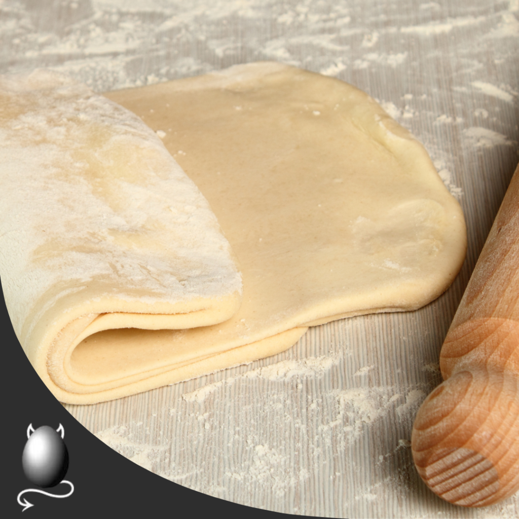 Puff Pastry Partially folded on a work surface with a rolling pin