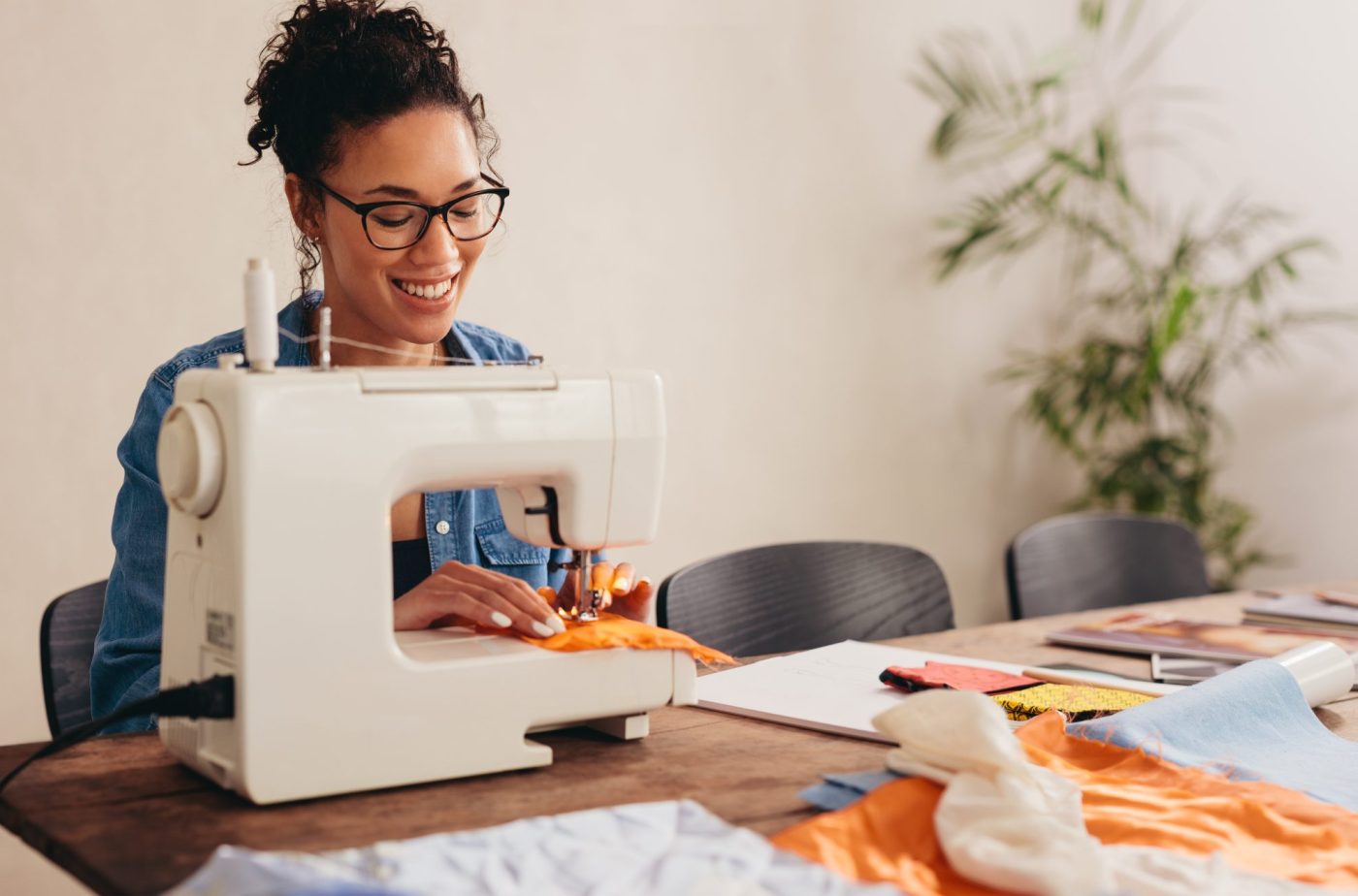 Woman sewing face mask at home. Woman using the sewing machine to sew the protective face mask.